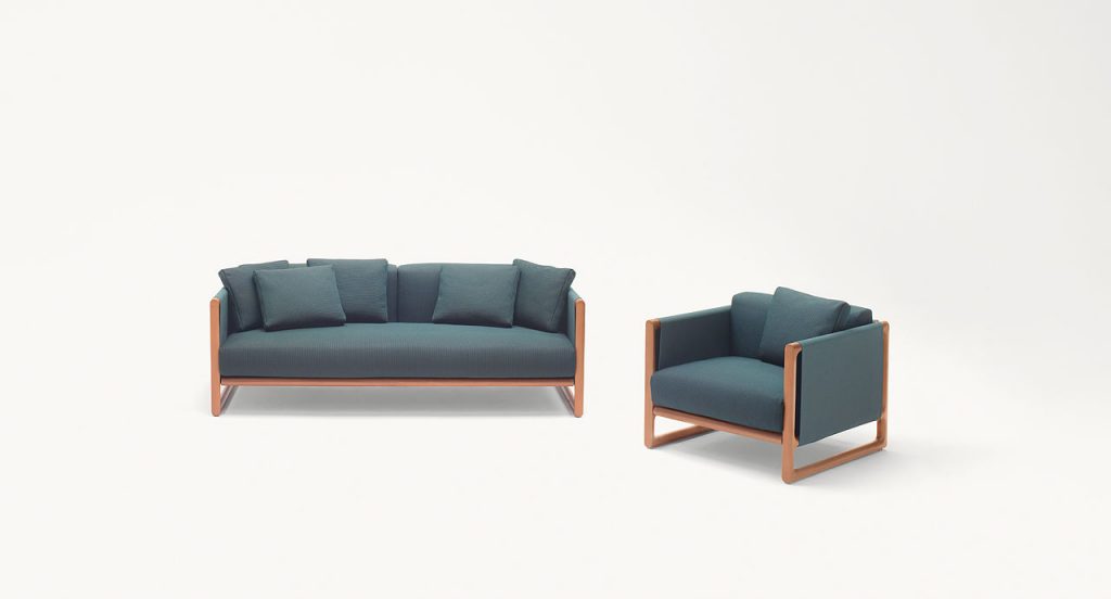 Portofino Outdoor Armchair, structure in natural heartwood, cushions in blue polyester in a living room.