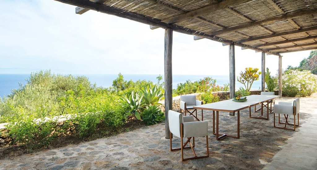 White Large Portofino Outdoor Dining Table, two legs in natural heartwood, top in natural lava stone in a dining room.