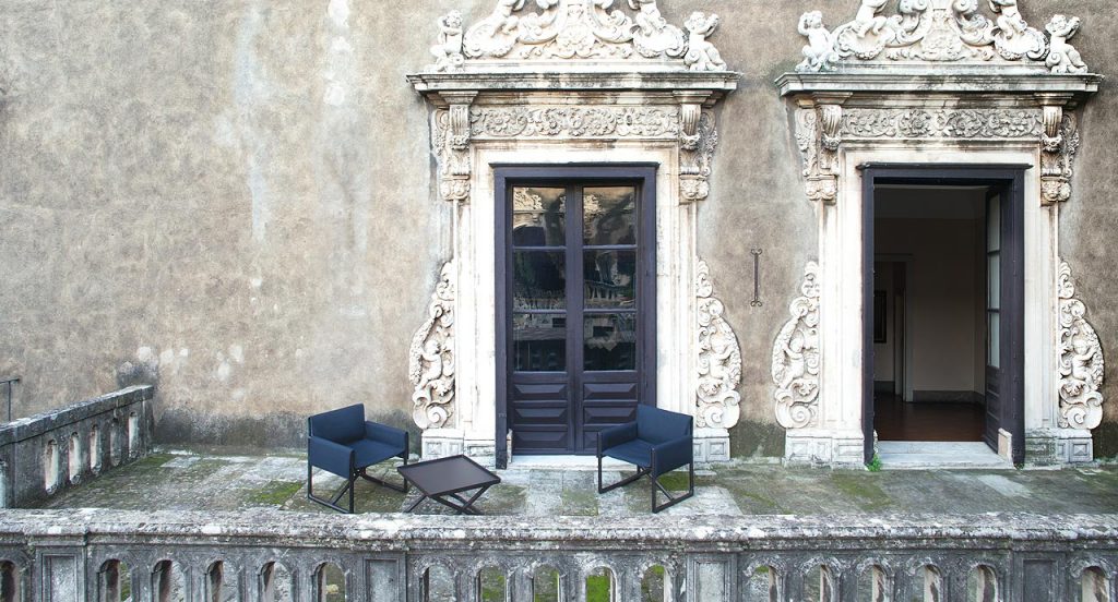 Portofino Outdoor Stool, structure in natural heartwood. Top in brown wood in a terrace.