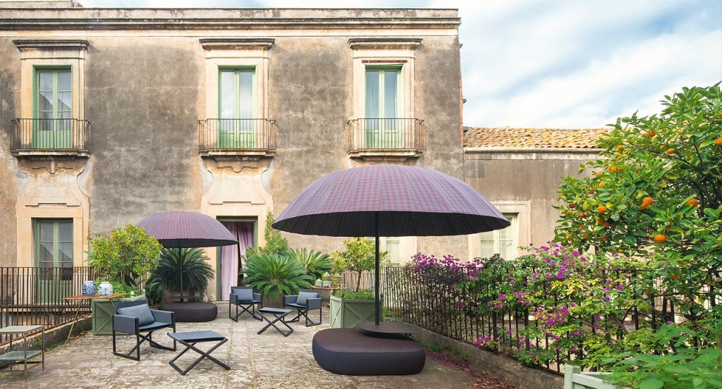 Portofino Outdoor Stool, structure in natural heartwood. Top in blue fabric in a terrace.