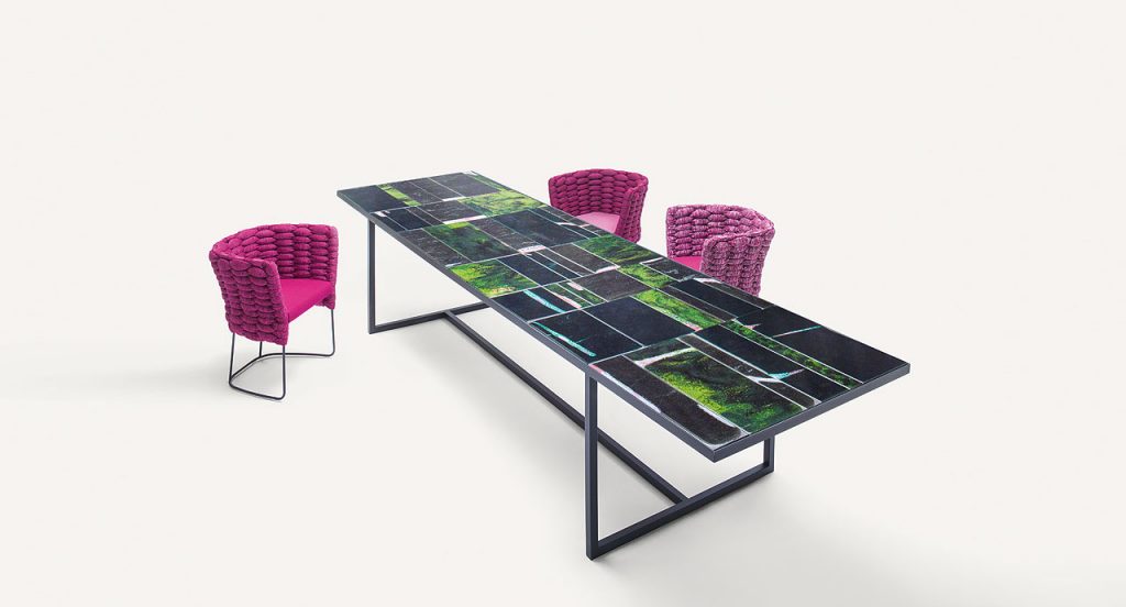 Green and black Sciara Dining Table, structure and two legs in steel, top in lava stone in a dining room.