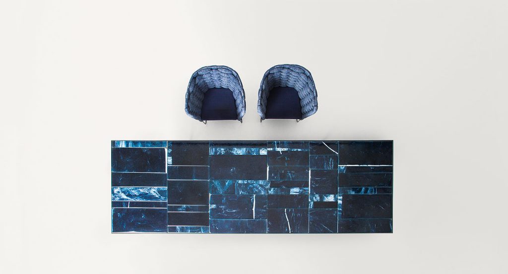 Blue Sciara Dining Table, structure and two legs in black steel, top in lava stone in a dining room.