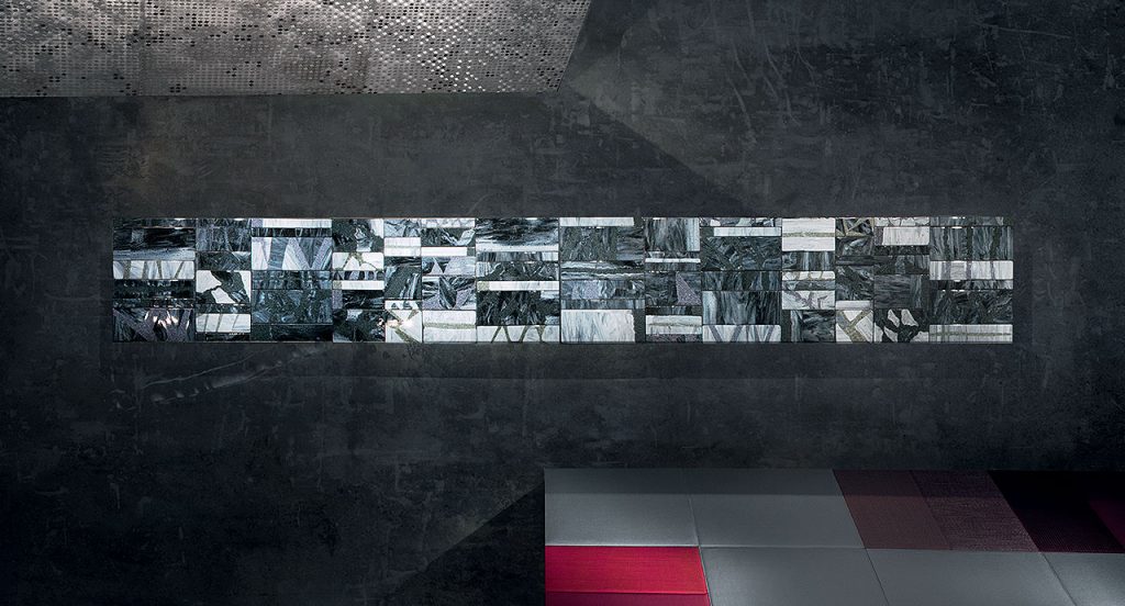 Grey, white and brown Sciara Dining Table, structure and two legs in black steel, top in lava stone in a grey room.