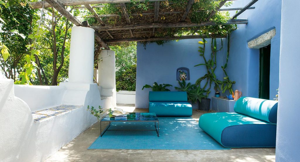 Sciara Side Table, structure in black steel, top in lava stone in blue in a living room.