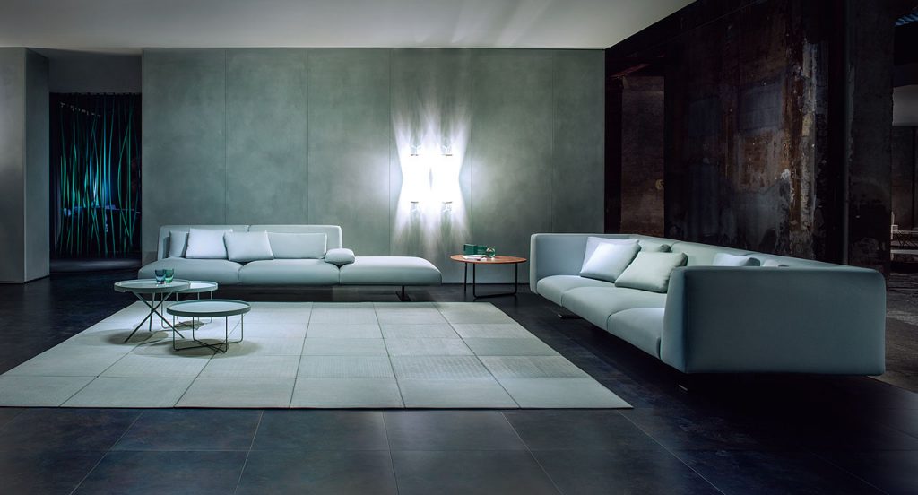 Two Move Sofas, upholstered in blue fabric, two legs in steel in a living room.