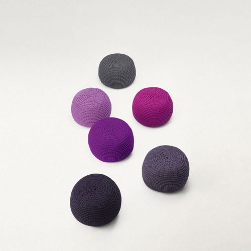 Six Picot Indoor Poufs, round shape, upholstery in wool cord, three in grey. two in purple and one in pink on a white background.