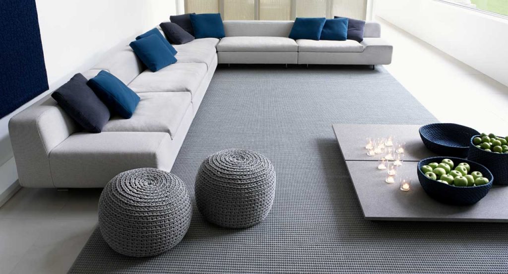 Two Picot Indoor Poufs, round shape, upholstery in grey wool cord in a living room.