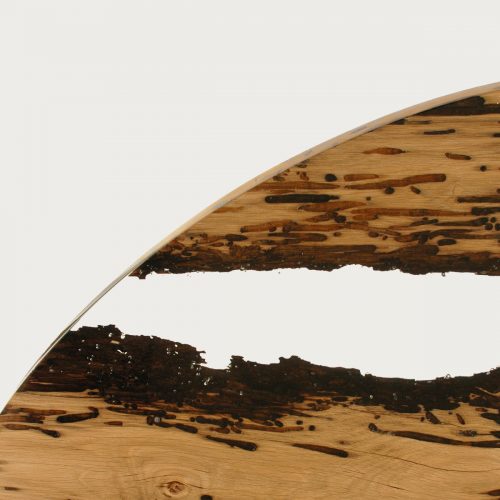 Closeup of Chimenti Round Table with a circular shape, made of solid wood with a natural finish and featuring a transparent resin inlay, set against a white background.