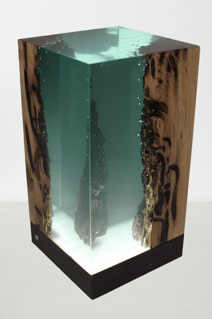 Abyss Lamp with a cubic shape, made of solid wood and transparent resin inlays and a black lampshade, on a white background.