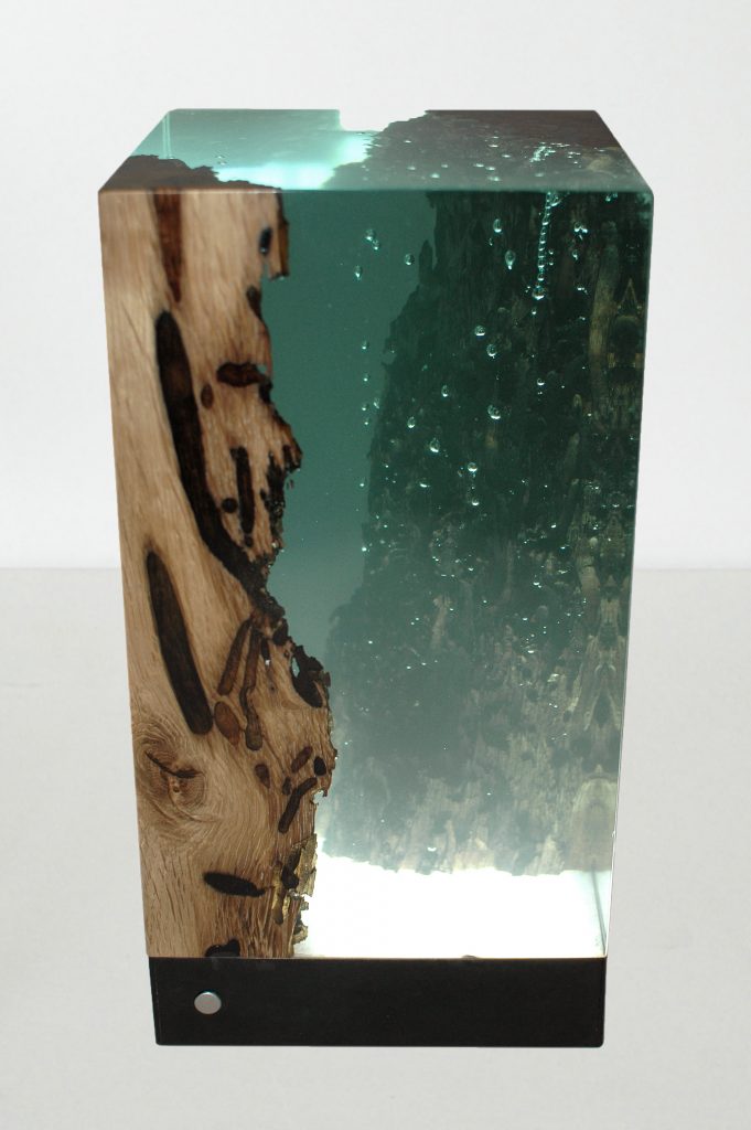 Abyss Lamp with a cubic shape, made of solid wood and transparent resin inlays and a black lampshade, on a white background.