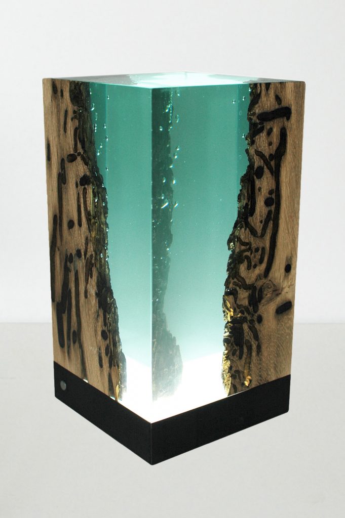 Abyss Lamp with a cubic shape, made of solid wood and transparent resin inlays and a black lampshade, on a white background.
