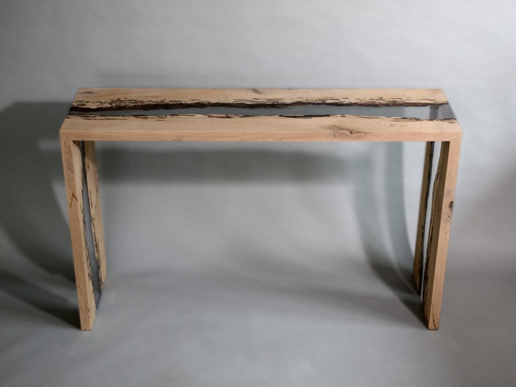 Bent River Console with an elongated shape, made of solid wood with a natural finish and featuring a transparent resin inlay, set against a white background.