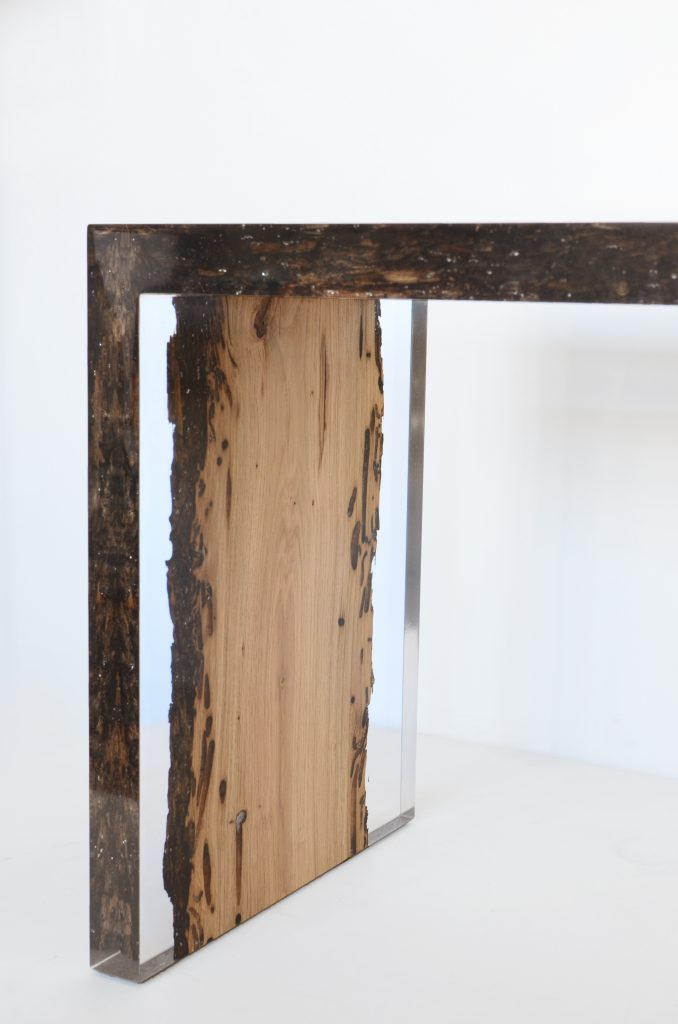 Closeup of Bent River Console with an elongated shape, made of solid wood with a natural finish and featuring a transparent resin inlay, on a white background.