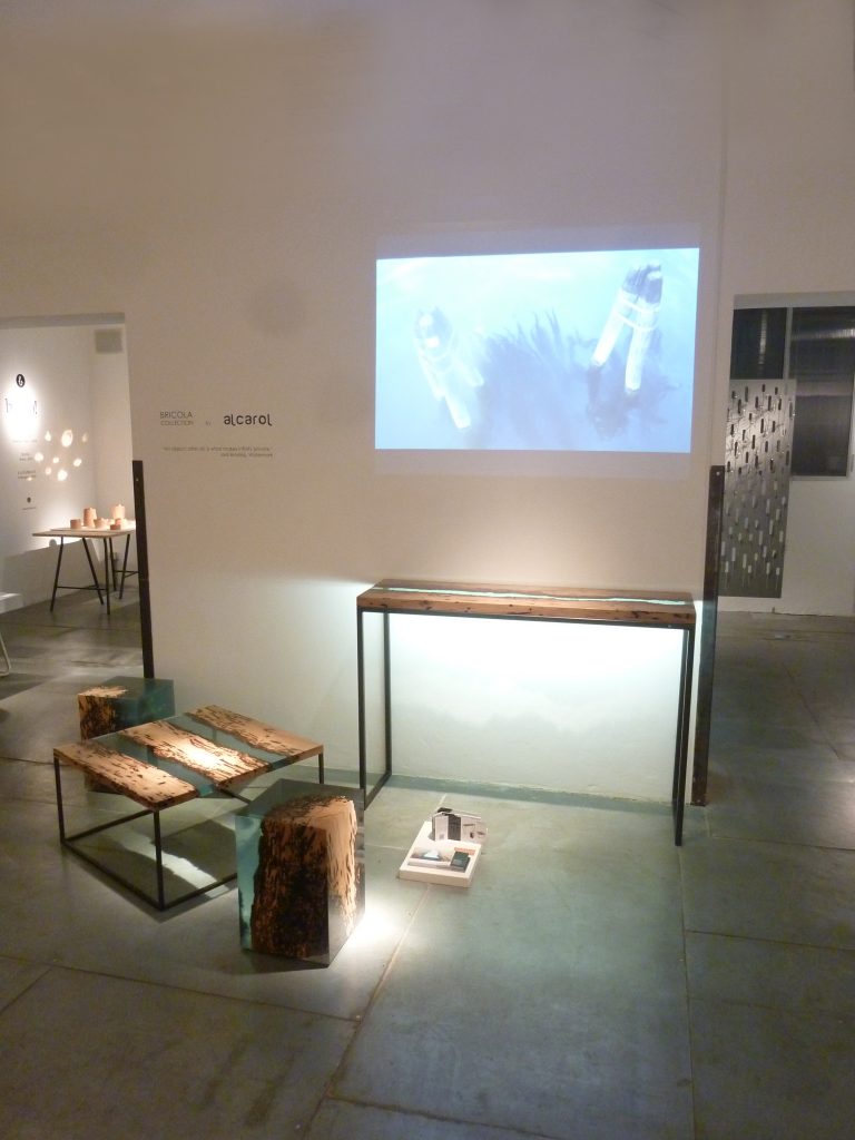 Two Anchor Stool/Side Tables with a cubic shape, made of solid wood and transparent resin inlays, in a showroom.