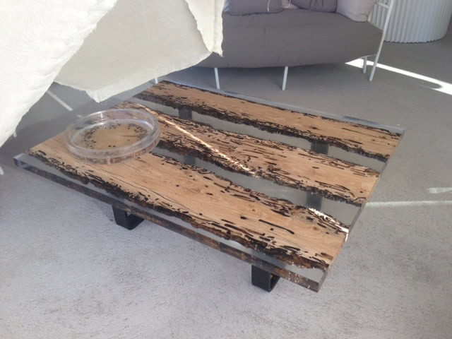 Chimenti Coffee Table with an elongated, rectangular shape, made of solid wood with a natural finish and featuring a transparent resin inlay in a living room.