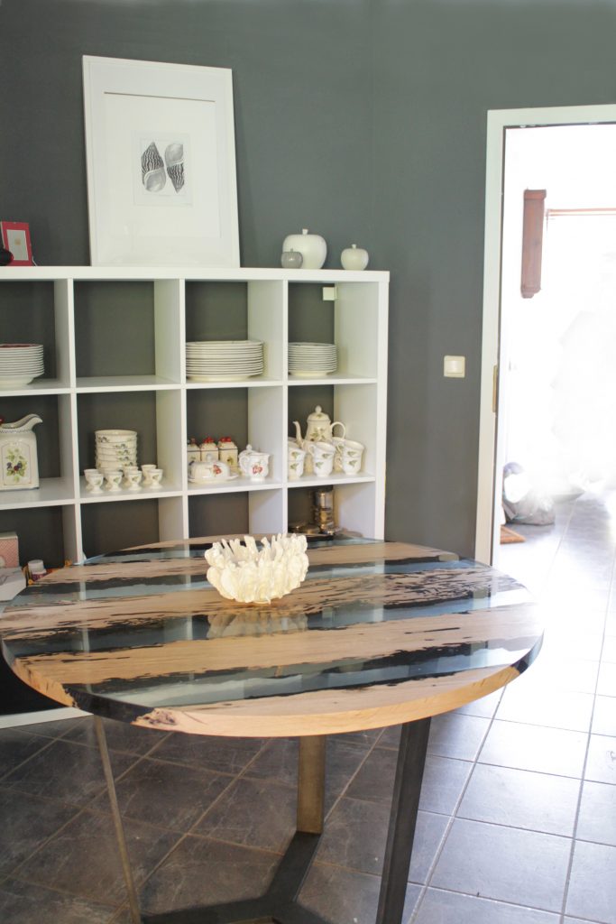 Chimenti Round Coffee Table with a circular shape, made of solid wood with a natural finish and featuring a transparent resin inlay, in a dining room.