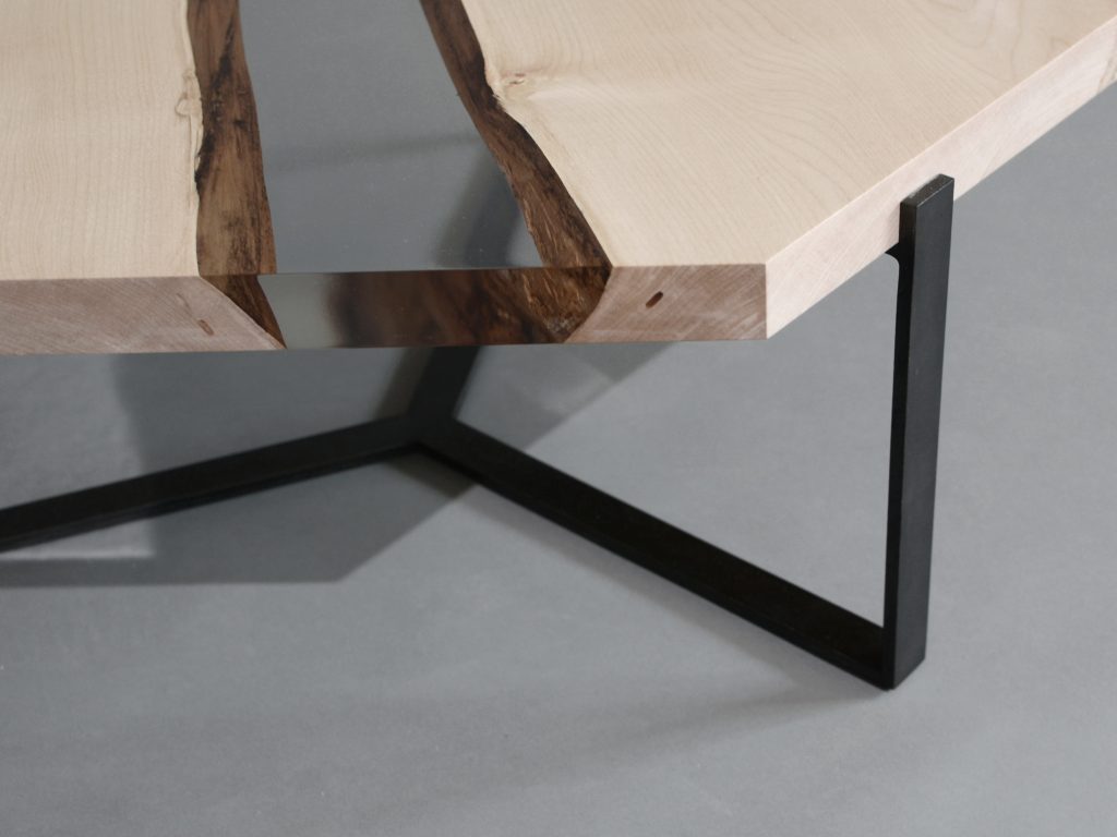 Closeup of Crystal Maple Low Table with a polygonal shape, made of solid maple wood with a natural finish and featuring a transparent resin inlay, set against a white background.
