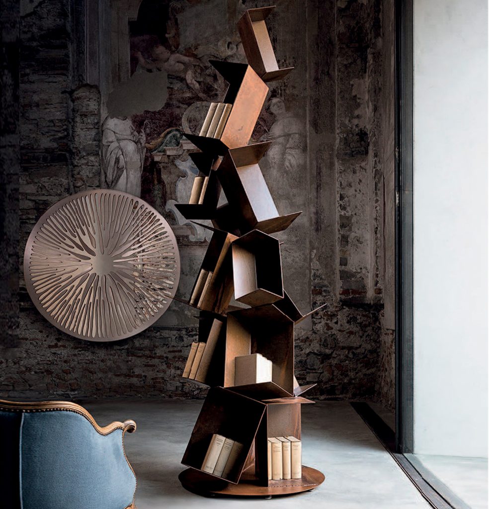 Sculptural bookcase in rusty iron in the shape of a sculptural pine tree in a room