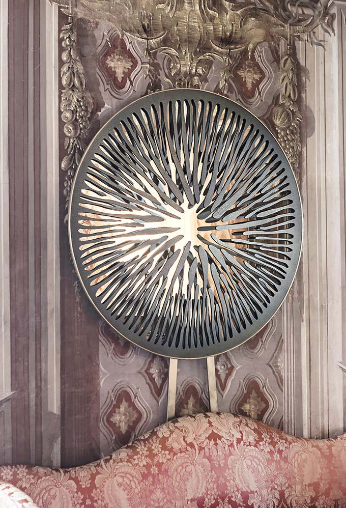sculptural mirror made of aluminum, graphite brass, bronze, steel or iron in a gray tone in a room