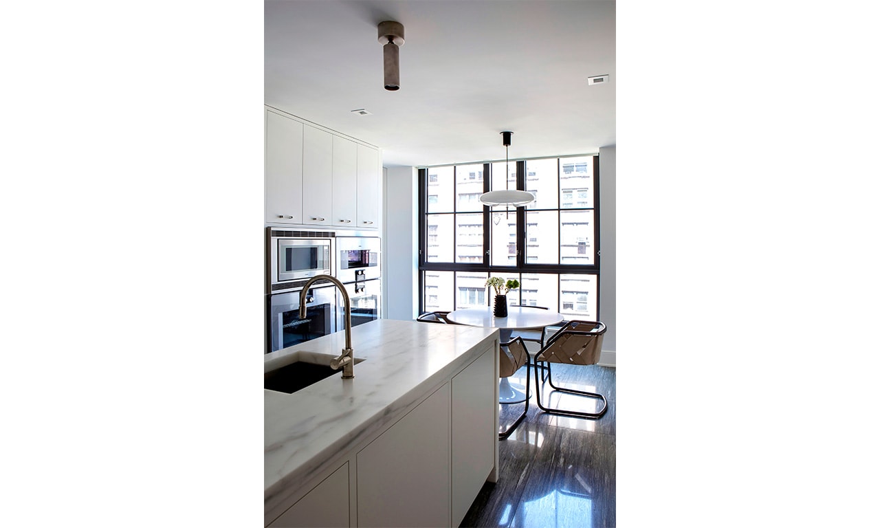 A sleek and modern kitchen featuring clean lines, ample natural light, and a sophisticated blend of white and metallic accents for a contemporary aesthetic.