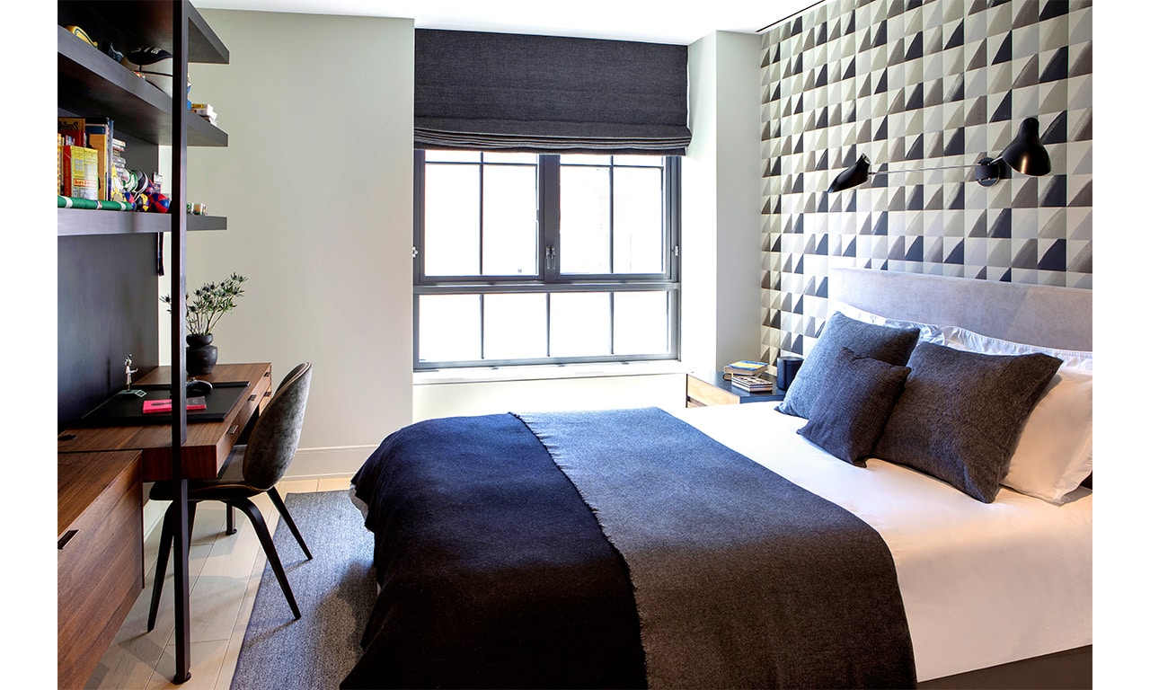 A modern bedroom featuring a bold accent wall, sleek furnishings, and a cozy atmosphere designed for both style and comfort.