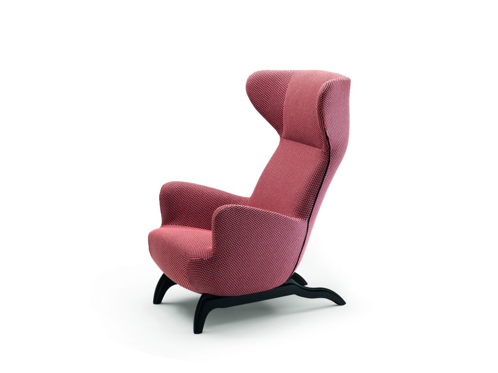 Ardea armchair with a pink fabric upholstery and black wooden legs on a white background.