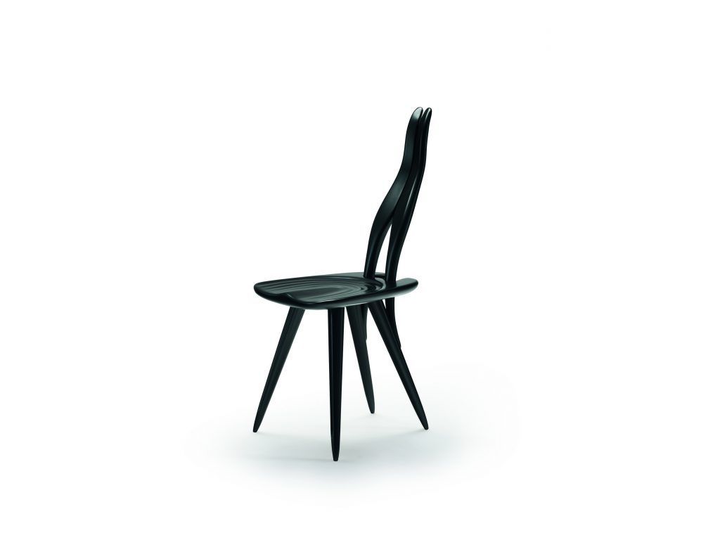 Fenis chair with a black frame, rabbit ears like shape back on a white background.