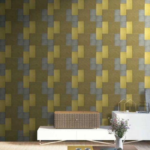 Maxime mosaic in brown, gray and yellow with rectangular patterns on a wall.