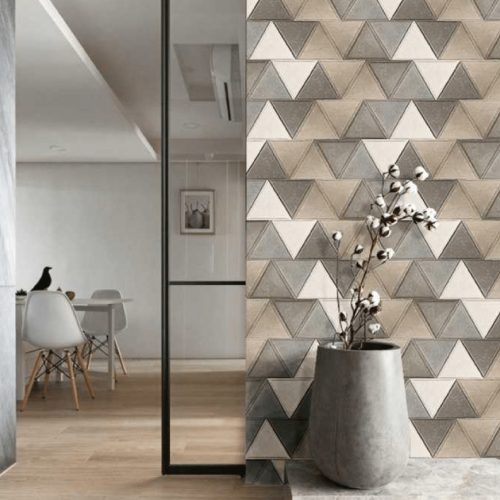 Simphony mosaic in white, brown and gray with a triangular pattern, set against a wall.