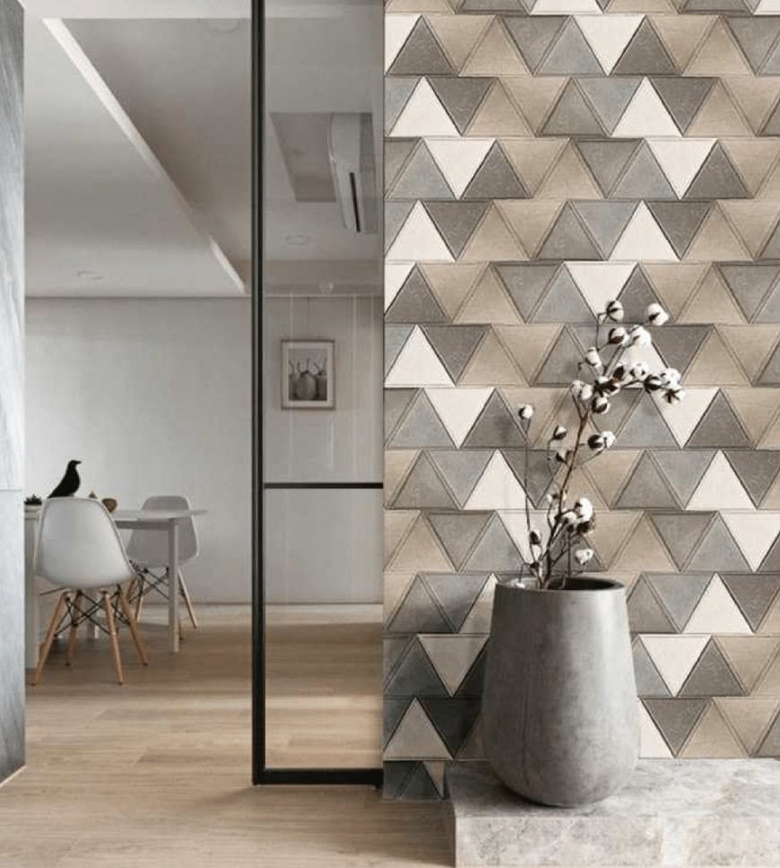 Simphony mosaic in white, brown and gray with a triangular pattern, set against a wall.