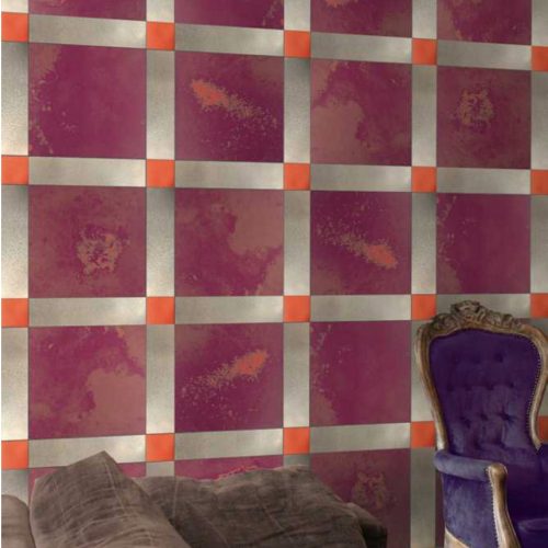 Unique mosaic with square shape in purple, orange and white set against a wall.