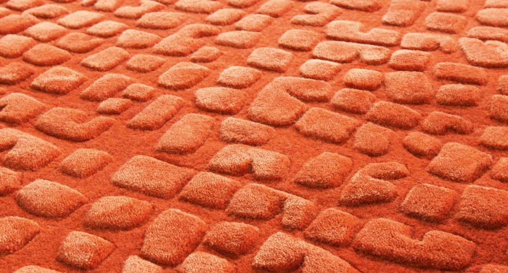 Red Signs rug, irregular geometric shapes in relief made of silk and wool.