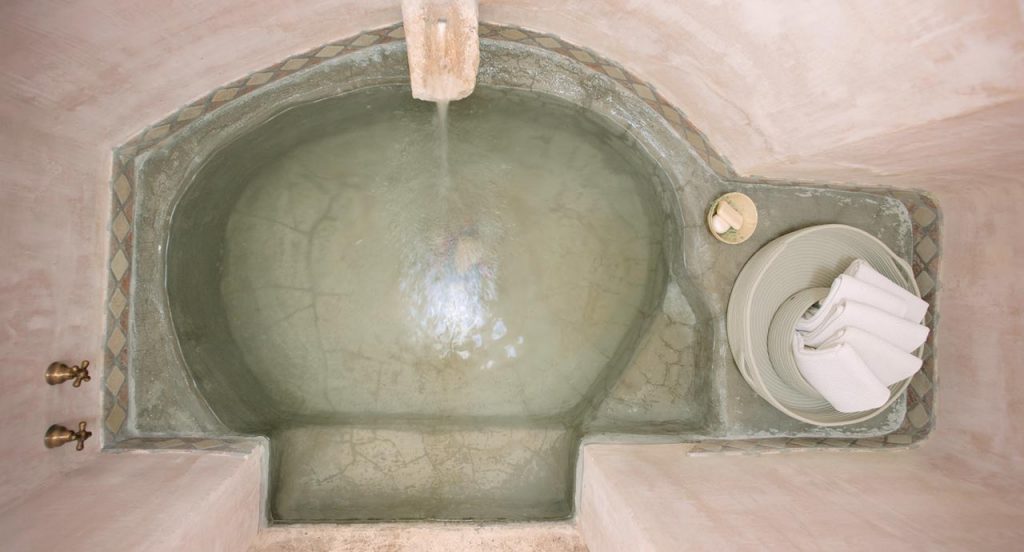 Two white Sika bowls made in rope cord next to a pool.