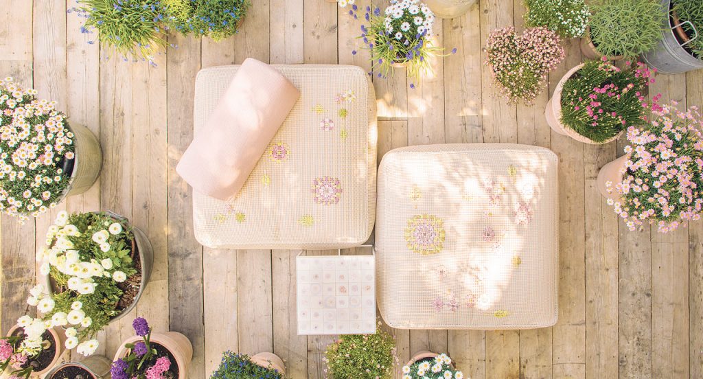 Two Square Spring Poufs in pink Kimia fabric embroidered upholstery in the garden.