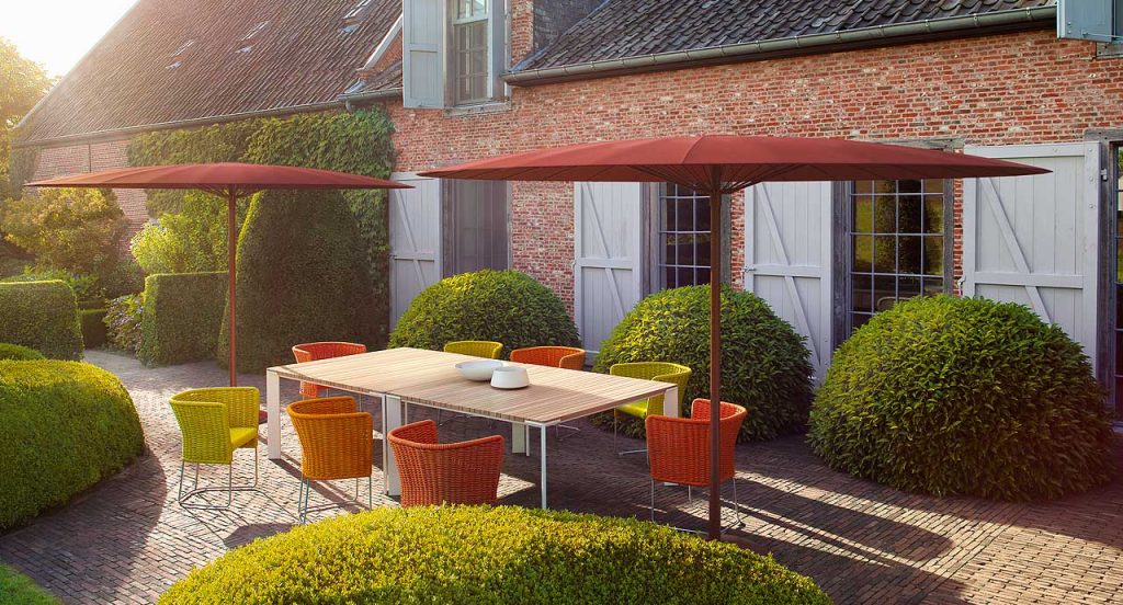 Rectangular Sunset Dining Table, top in natural wood, structure and four legs in steel in an outdoor place.