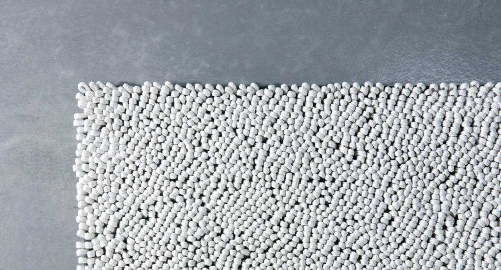 White Wind Low rug in Round Rope braid style on a grey background.