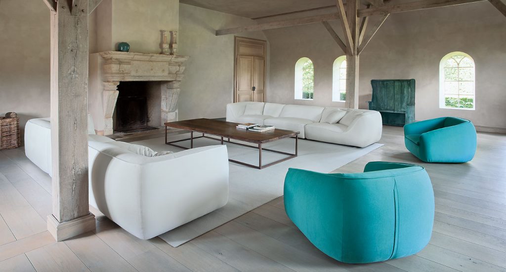 Two white So Sofas, three seater, fabrics upholstery, wood base in a living room.