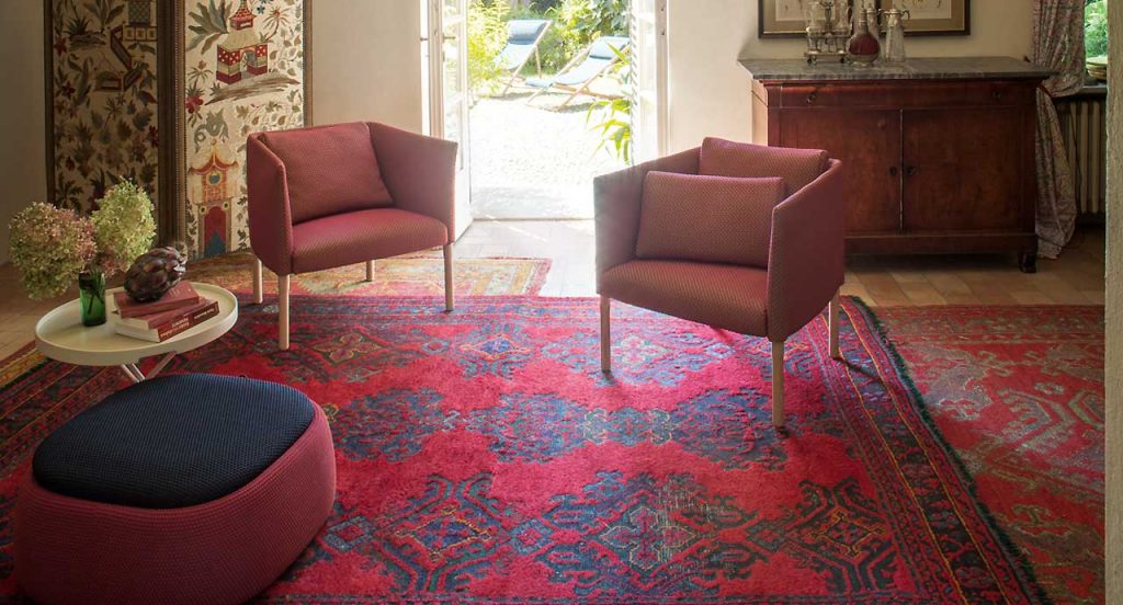 Smile Indoor Pouf, upholstered in blend y dots black and red fabric in a living room.