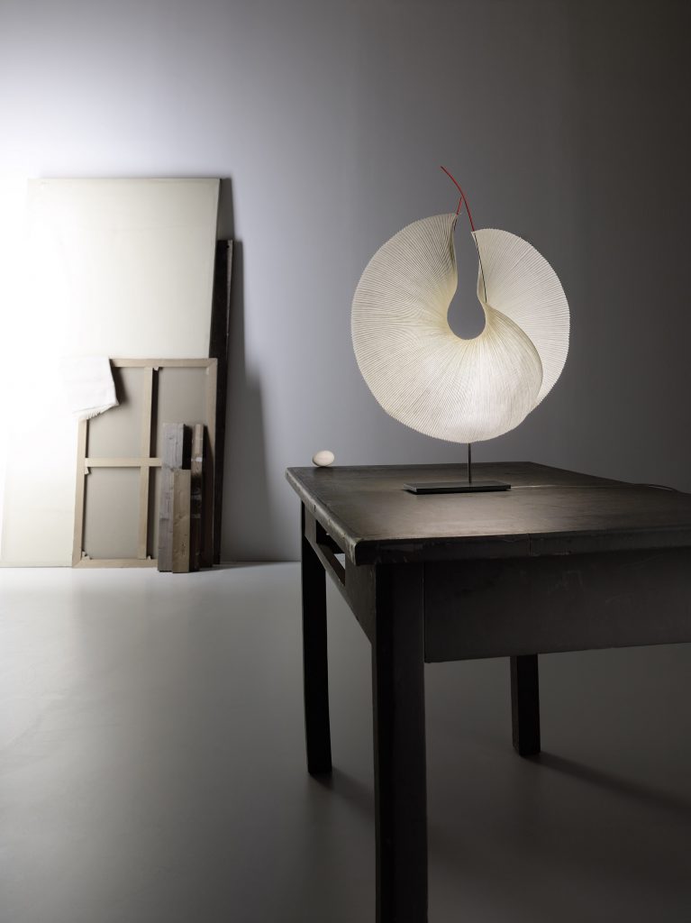 A table with a Yoruba Rose lamp on top of it