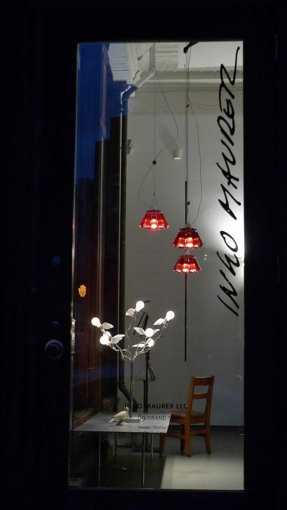 A room with a table, chair, and Birdies Busch lamp in it