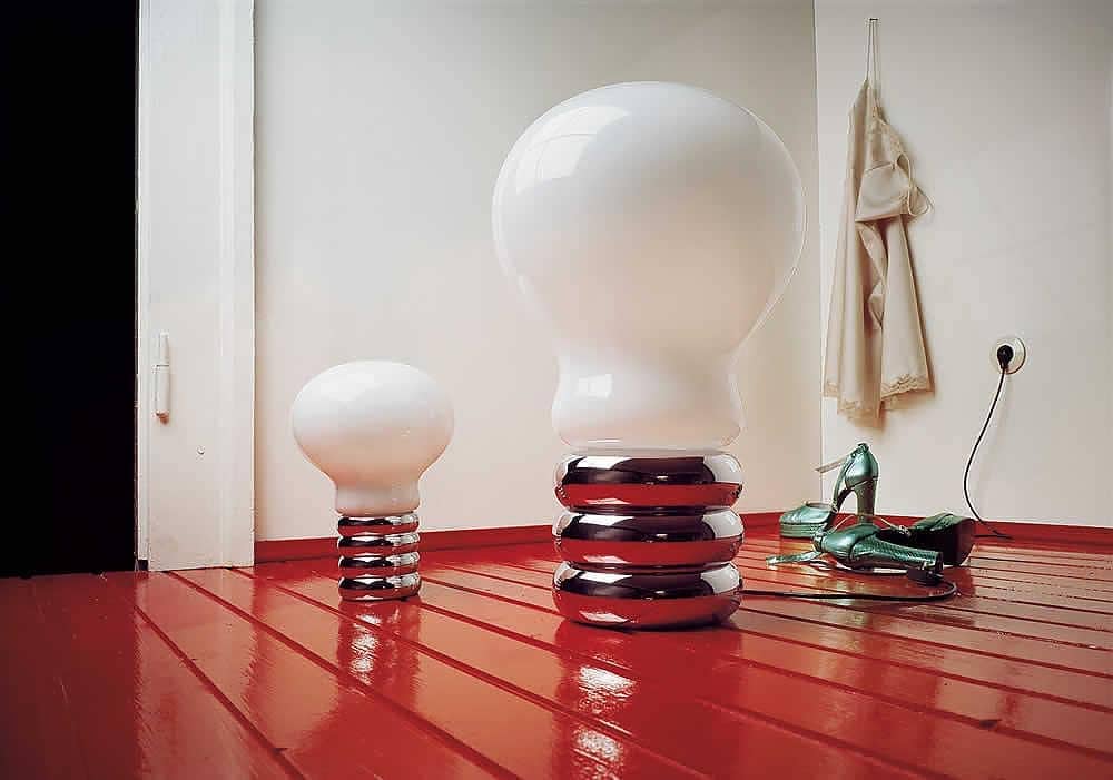 Bulb in a large and small size with a white coating over the top sitting on a red wooden floor