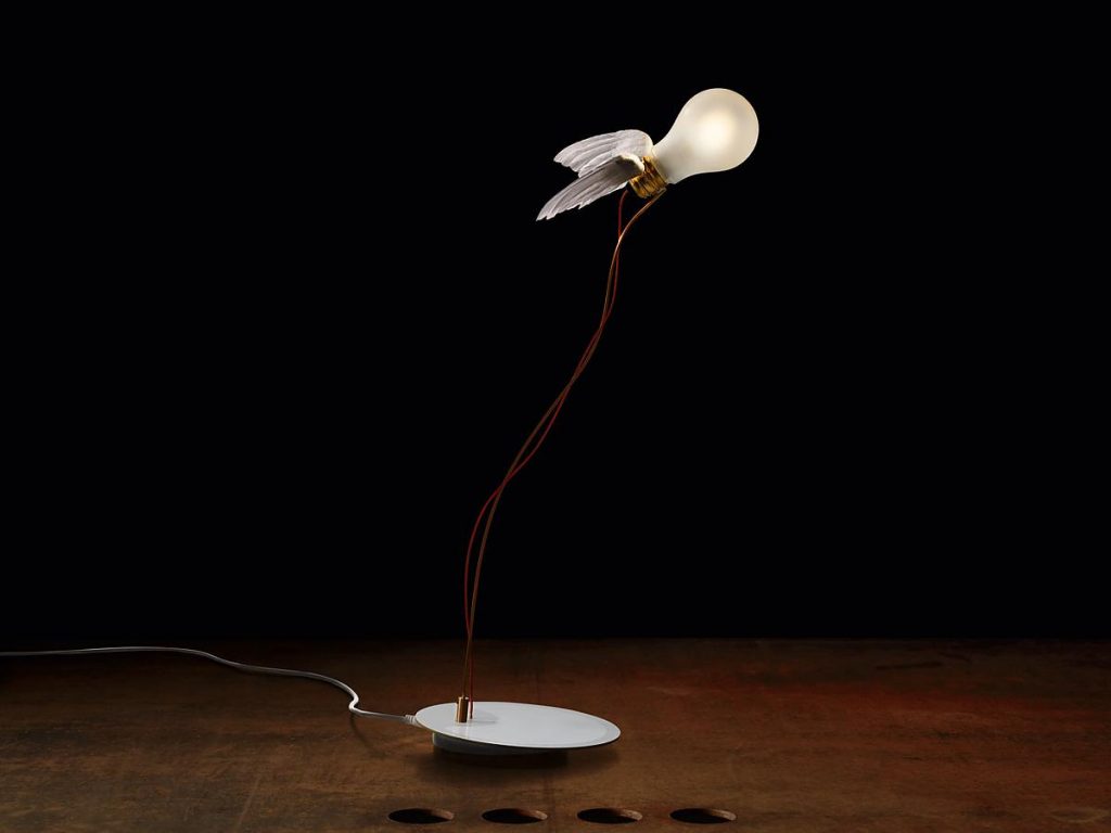 A Lucellino light on a wooden table with a black background