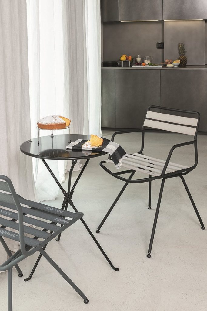 two chairs made with a gray iron base and elastic strips in a beige tone in a dining room