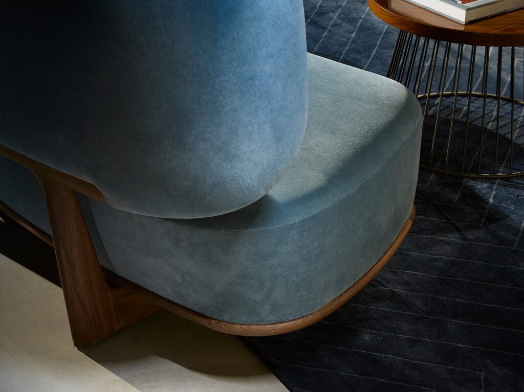 large cushion made of blue-colored fabric and resting on brown-colored wood in a living room