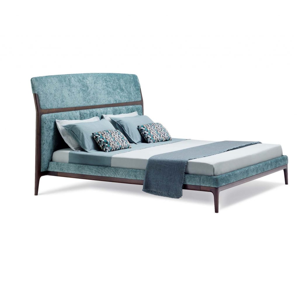 bed made of a wooden base upholstered in velvet fabric in a tone of blue with white on a white background