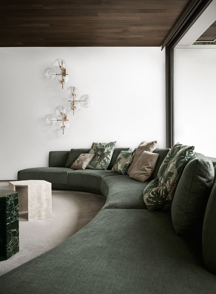large modular sofa made of internal wood lined with foam and upholstered in fabric or leather in a green tone