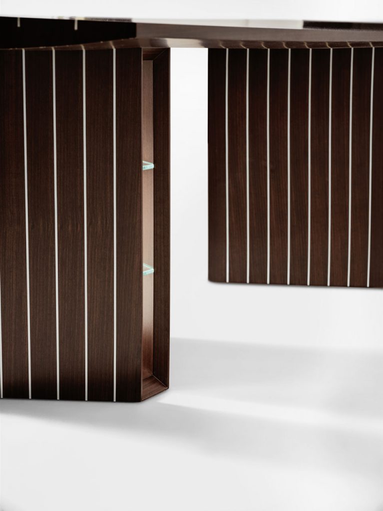 Desk in Indian Rosewood on a wooden base in a brown tone in an office on a white background