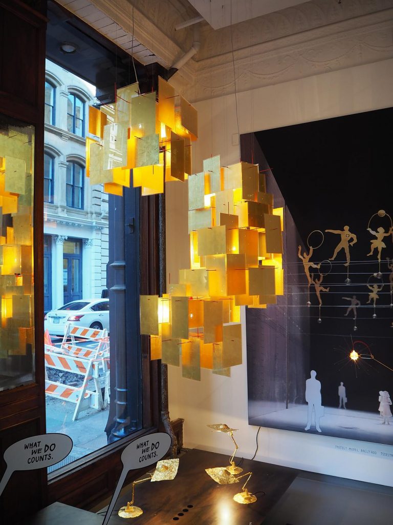 A 1000 Karat chandelier hanging from a ceiling in front of a window in a room