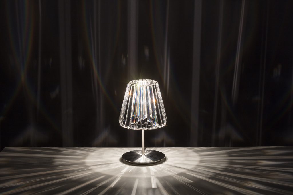 table lamp made of bohemian crystal base and steel base base in a tone of iridescent color on a black background