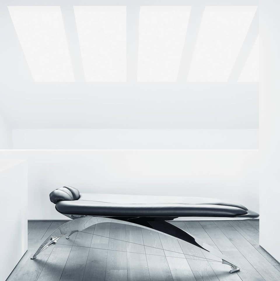 reclining table made of corrugated steel base in a silver tone upholstered in black leather tone